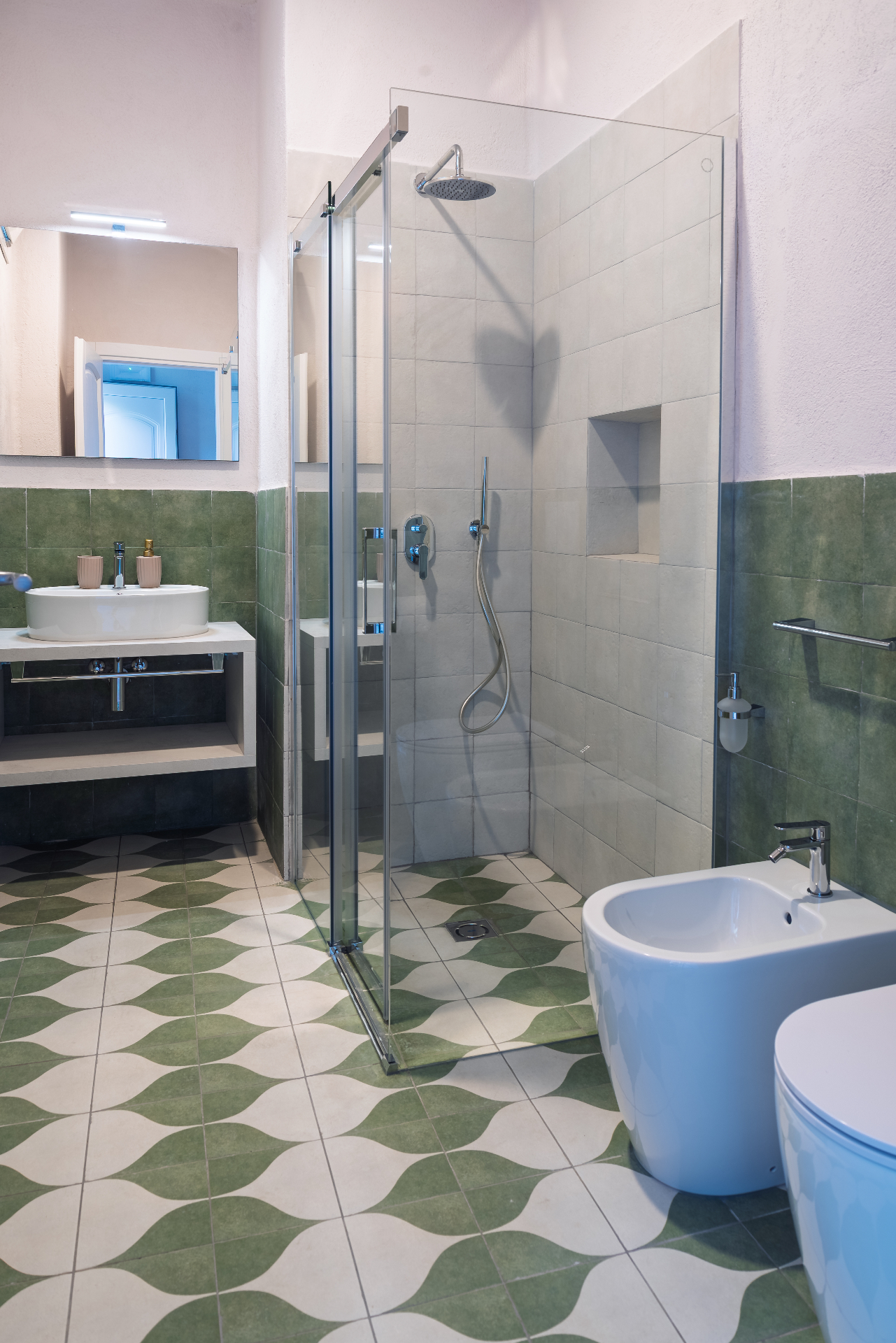 Bagno Vasame con doccia in vetro e pavimento a onde verdi